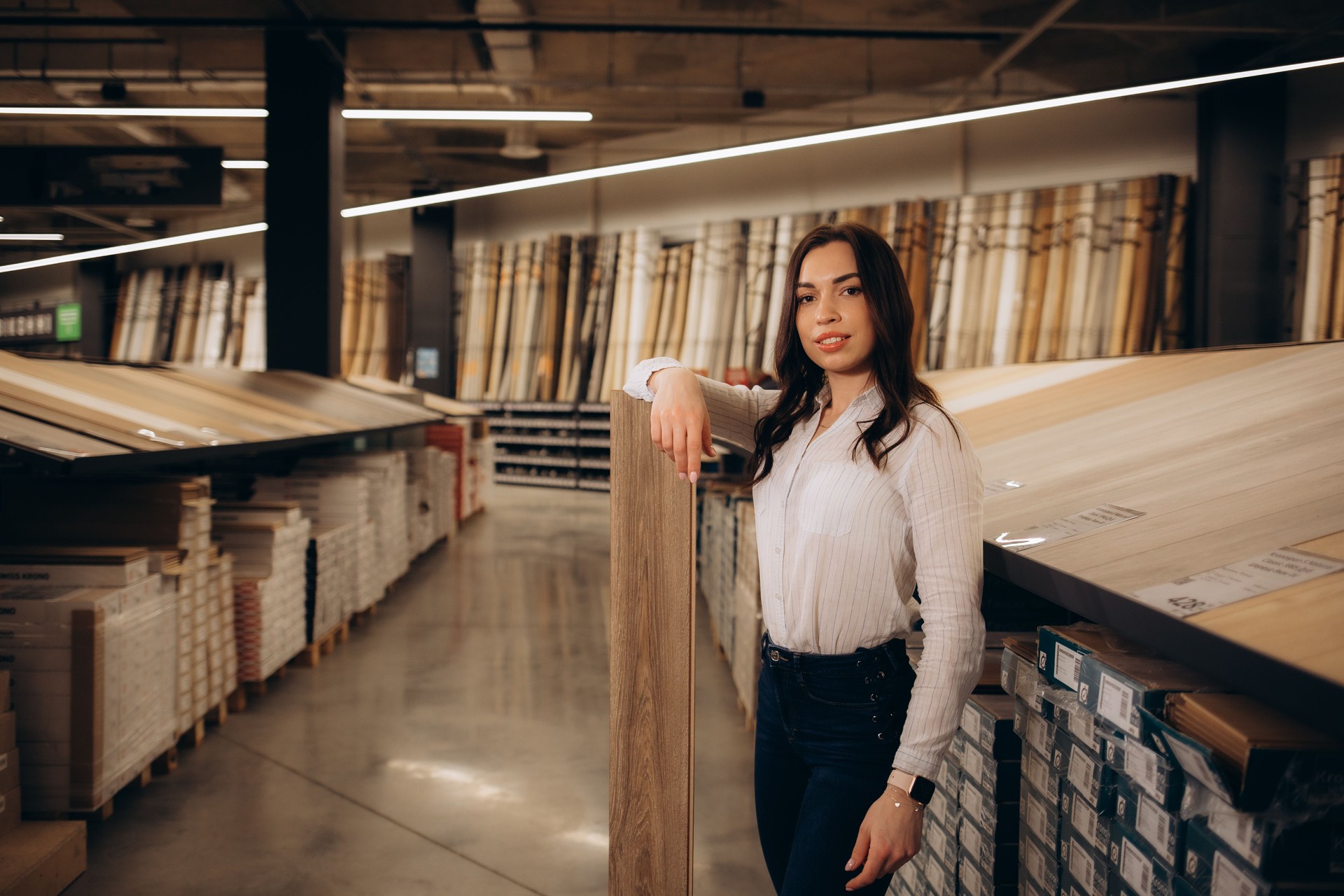 Woman chooses laminate flooring in hardware store. High quality photo